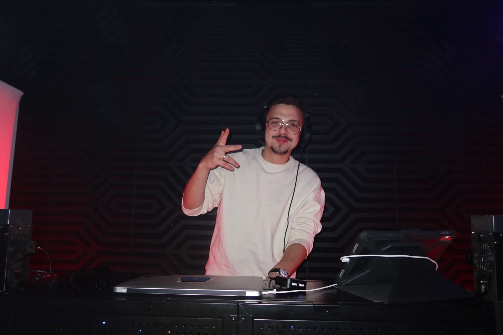 ARSKGG behind the DJ booth in a dark club