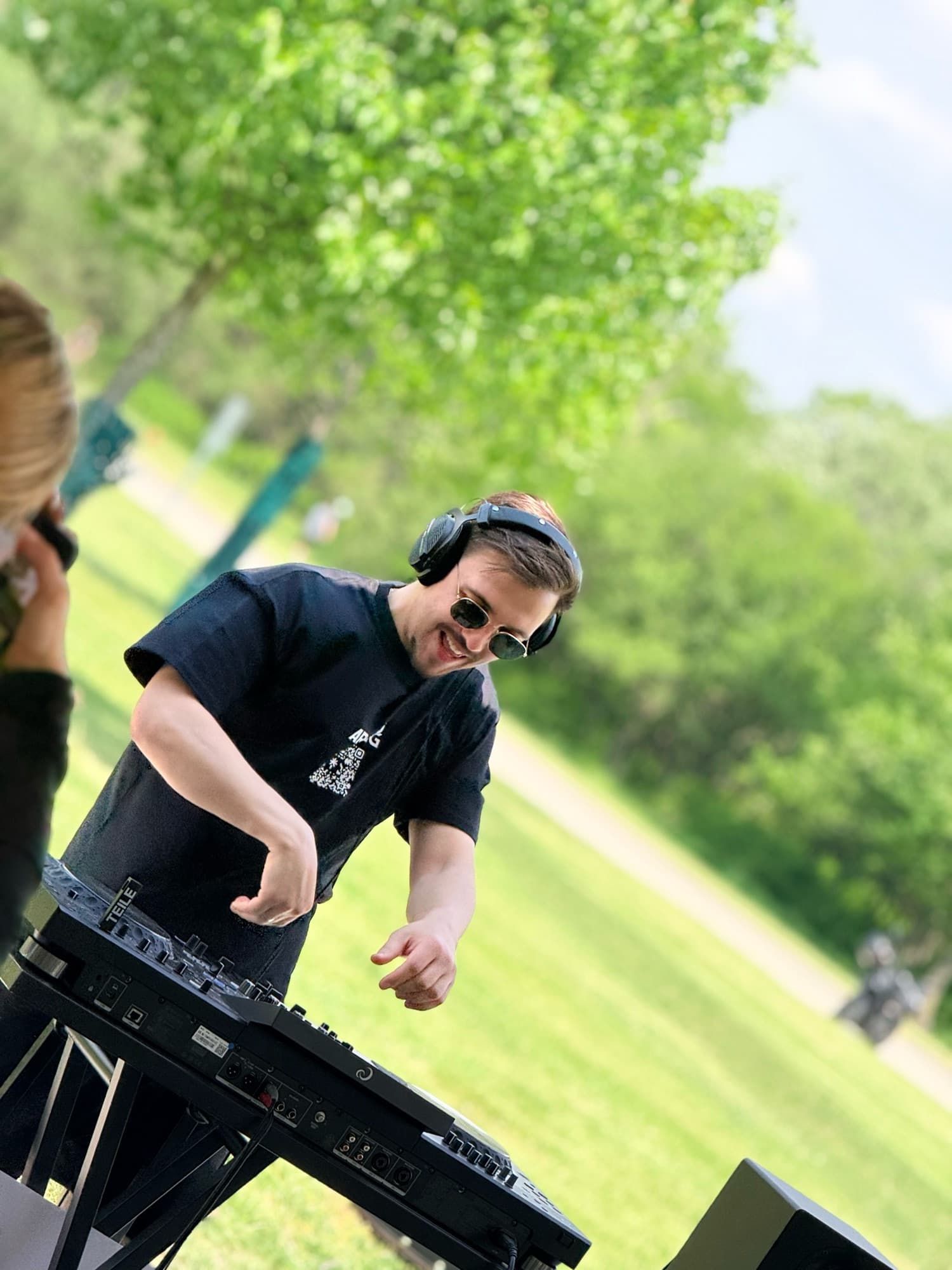 ARSKGG DJing outdoors on a grassy hill