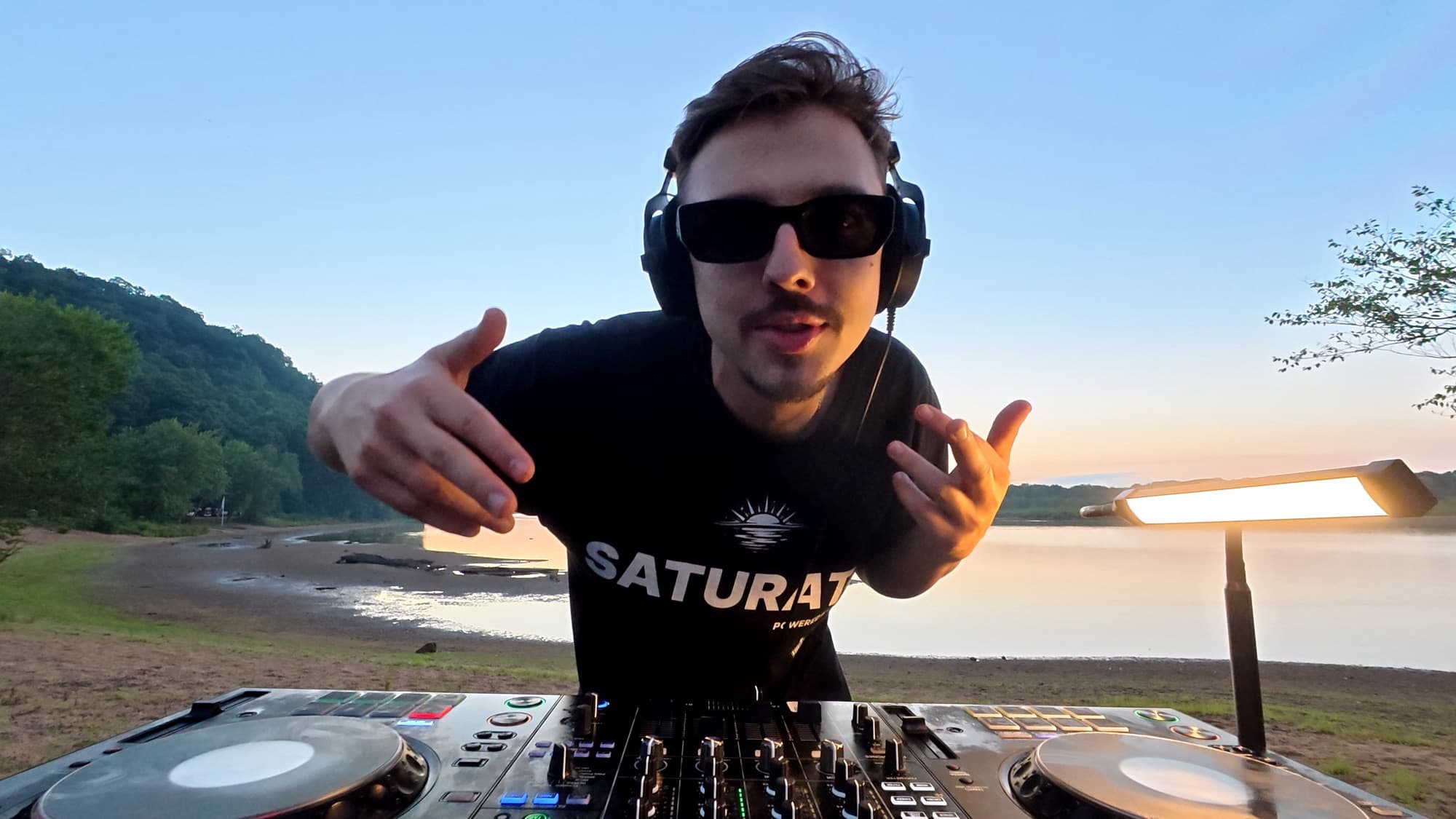 ARSKGG reaching toward the camera during a sunrise set by the water